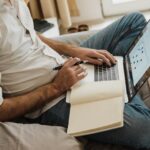 met laptop op de bank